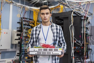 Young man holding ethernet switches