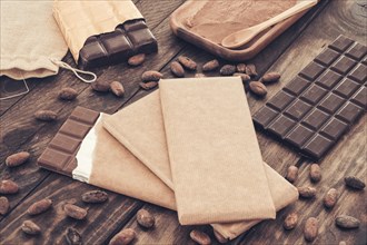 Dark chocolate bars with cocoa beans wooden table