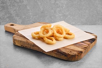 Deep fried spicy onion rings on parchment