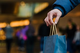 Mans hand holding shopping bag