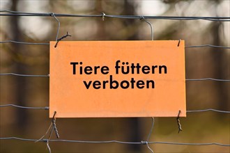 German sign saying 'Feeding animals prohibited' hanging on fence