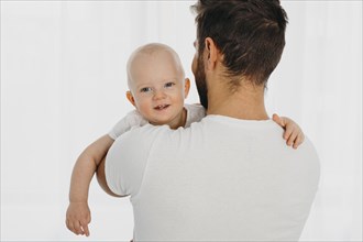 Back view father holding baby