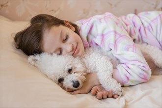 Girl hugging her dog bed while sleeping