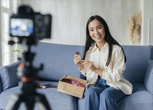 Woman live streaming home with make up tools
