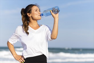 Woman staying hydrated beach while working out