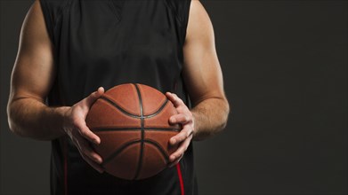 Front view basketball held by male player with copy space
