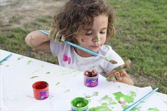 Messy girl painting canvas park