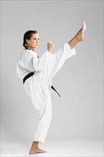 Young adult woman with black belt fighter training karate