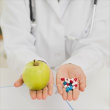 Doctor holding green apple pills