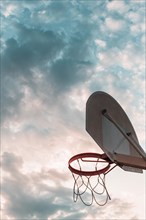 Low angle view basketball hoop against cloudy sky