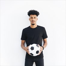 Young black man with ball looking camera