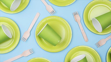 Green plates with cups cutlery flat lay