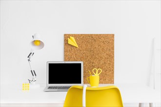 Stylish workspace yellow white colors with cork board