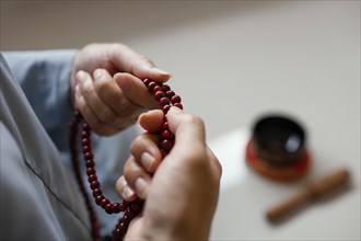 High angle woman holding beads meditating