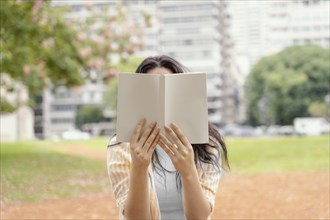 Young woman reading interesting book