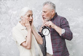 Elder couple holding clock