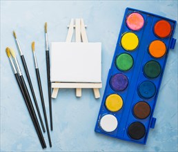 Top view paint brushes mini easel watercolor palette