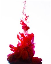 Vivid red ink swirling underwater
