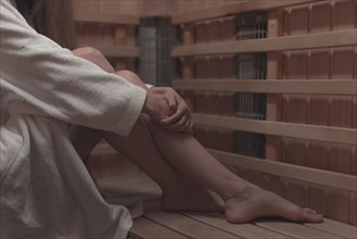 Low section woman sitting wooden bench sauna