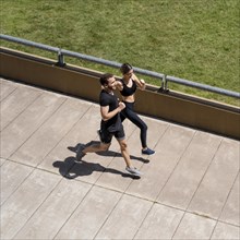 High angle man woman jogging together outdoors