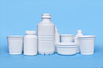 Different plastic waste packages on blue background