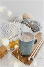 High angle hot chocolate wooden board with blanket lights
