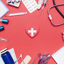 Medical supplies around heart with cross