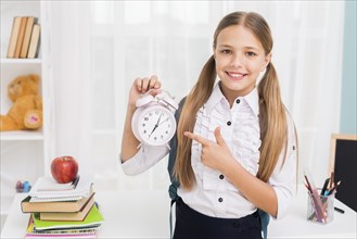 Positive schoolgirl pointing clock