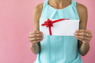 Woman holding envelope with ribbon