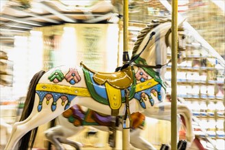 Nostalgic horse detail carousel spinning with light blurs night