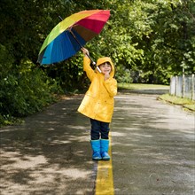 Little boy holding umbrella his head