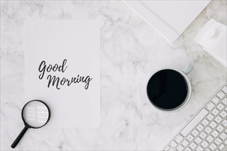 Magnifying glass good morning paper with coffee cup diary keyboard white marble desk