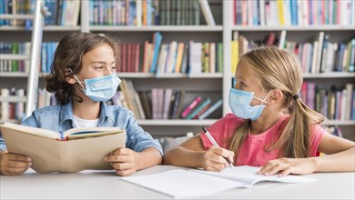 Kids doing their homework while wearing medical mask