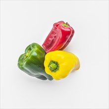 High angle view green yellow red bell peppers white background