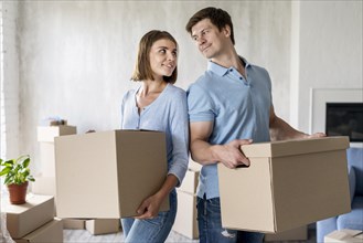 Couple holding boxes moving out day