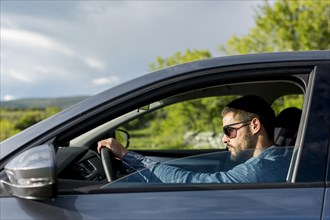 Brutal male with sunglasses driving car