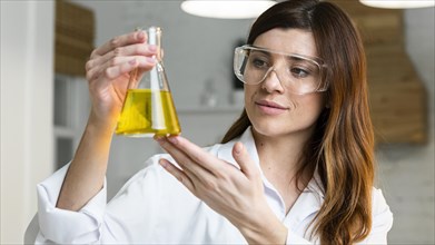 Female scientist with safety glasses holding test tube
