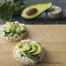 Close up rice cake with avocado slices wooden chopping board