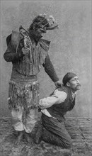 Shaman holding a man on his knees