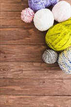 Multi colored ball yarns wooden background
