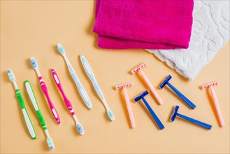 Plastic razor with tooth brushes towel colored background