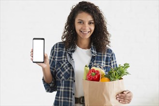 Woman holding vegetables bag phone mock up