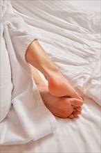 Closeup view of female sole and toes on bed