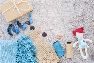 Wrapped gift box measuring tape buttons spool doll textured backdrop