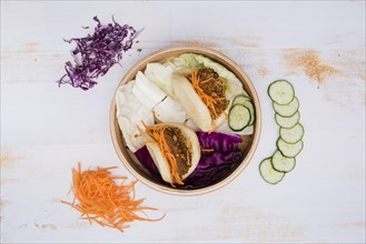 Elevated view taiwan s traditional food gua bao steamer with salad wooden texture backdrop