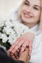 Man placing diamond engagement ring finger his fiancee