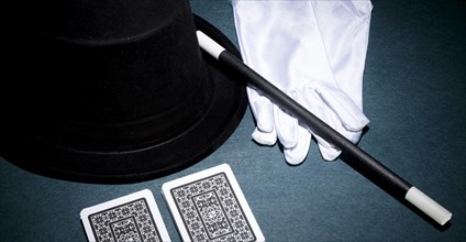 Panoramic view playing card white gloves top hat magic wand green background