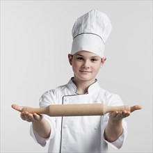 Portrait young master chef holding rolling pin