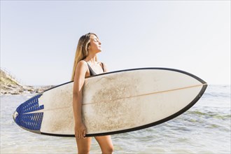 Pretty woman swimsuit walking with surfboard sea