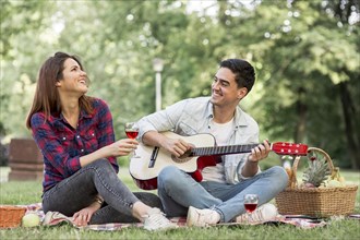 Couple singing playing guitar park